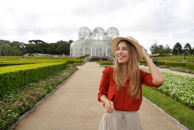 Girl with hat walking looking to the side in the botanical garden of curitiba, parana, brazil