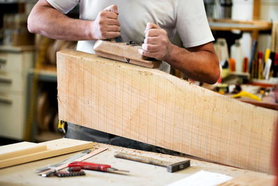 Midsection of carpenter working in workshop