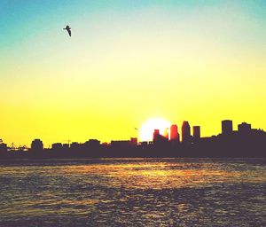 Silhouette of city against sky during sunset