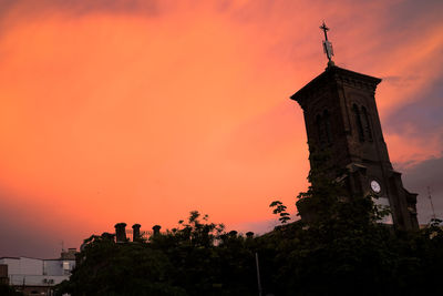 Low angle view of tower against orange sky