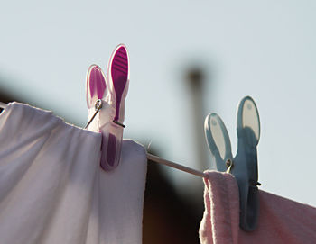 Close-up of clothes drying on clothesline against white wall