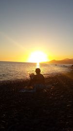 Tourists on beach during sunset