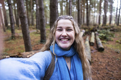 Happy beautiful woman taking selfie in cannock chase forest