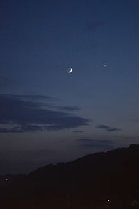 Low angle view of silhouette moon against sky at night