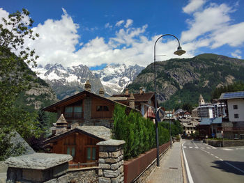 Street amidst buildings and mountains against sky