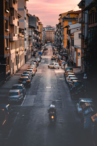 Cars on city street against sky