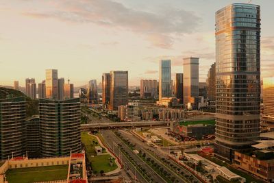 Aerial view of buildings in city against sky during sunset