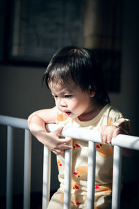 Cute baby girl in crib at home