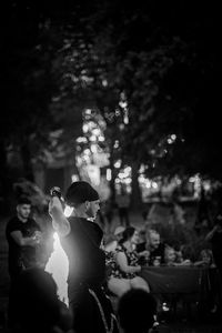 Group of people on tree trunk at night