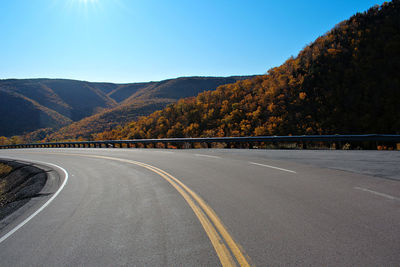 Road by mountain against sky