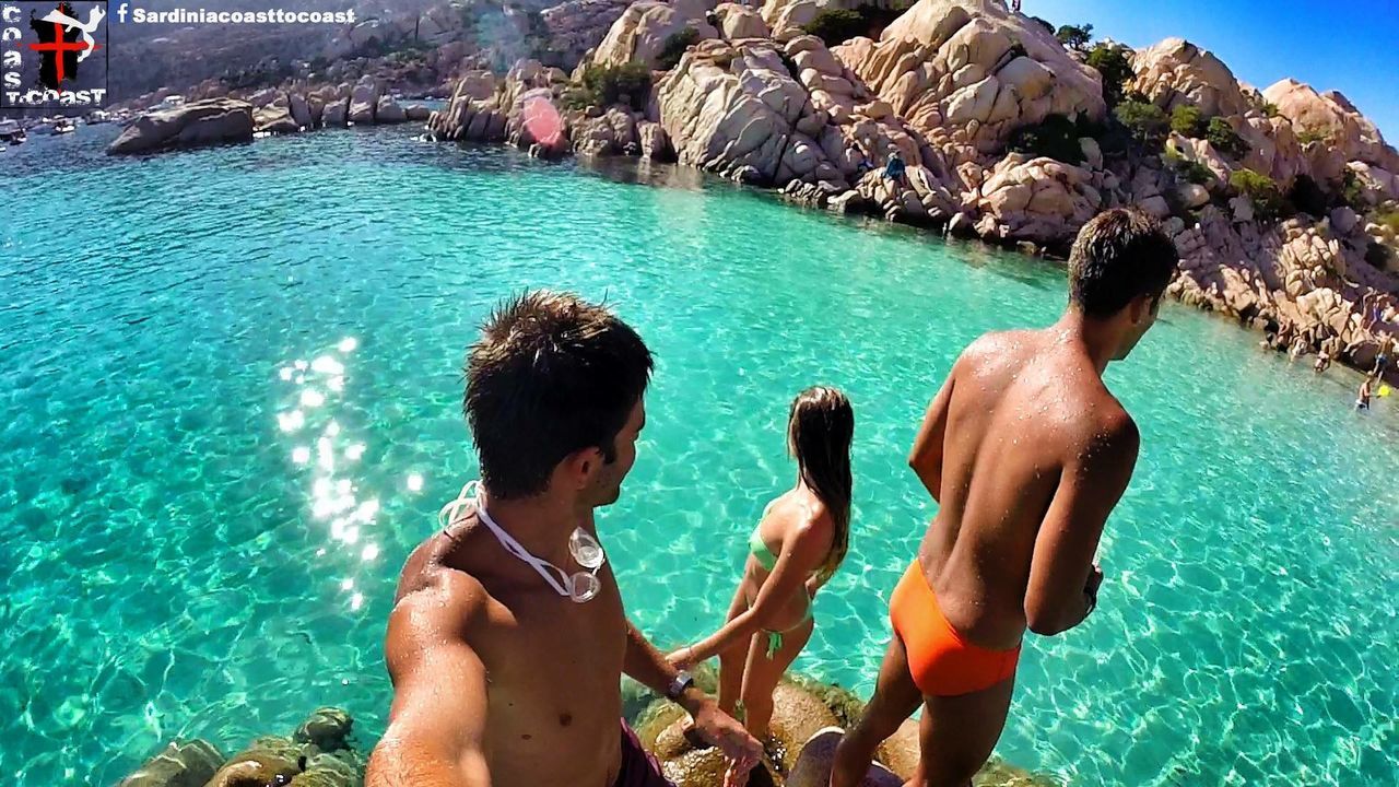 water, sea, leisure activity, lifestyles, blue, togetherness, vacations, men, person, bonding, summer, rock - object, enjoyment, weekend activities, sunlight, nature, shirtless