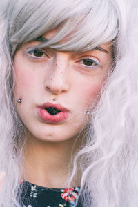 Close-up portrait of female model eating blackberry