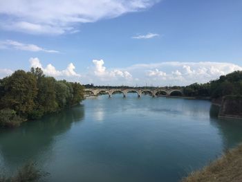 Arch bridge over river against sky