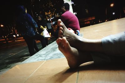 Low section of couple sitting on street