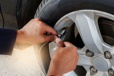 Cropped hands of mechanic repairing car tire