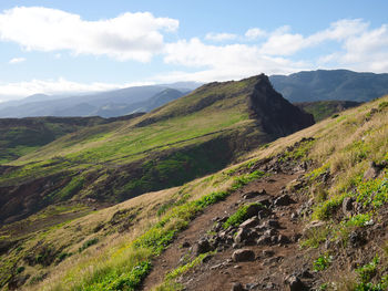 Scenic view of green landscape and mountains against sky