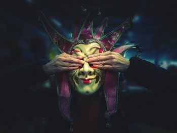 Close-up of woman holding flower at night