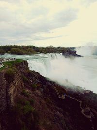 Scenic view of river against cloudy sky