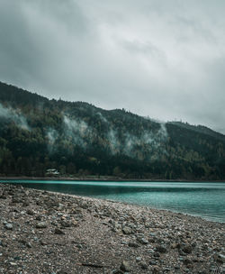 Scenic view of sea and mountains against sky
