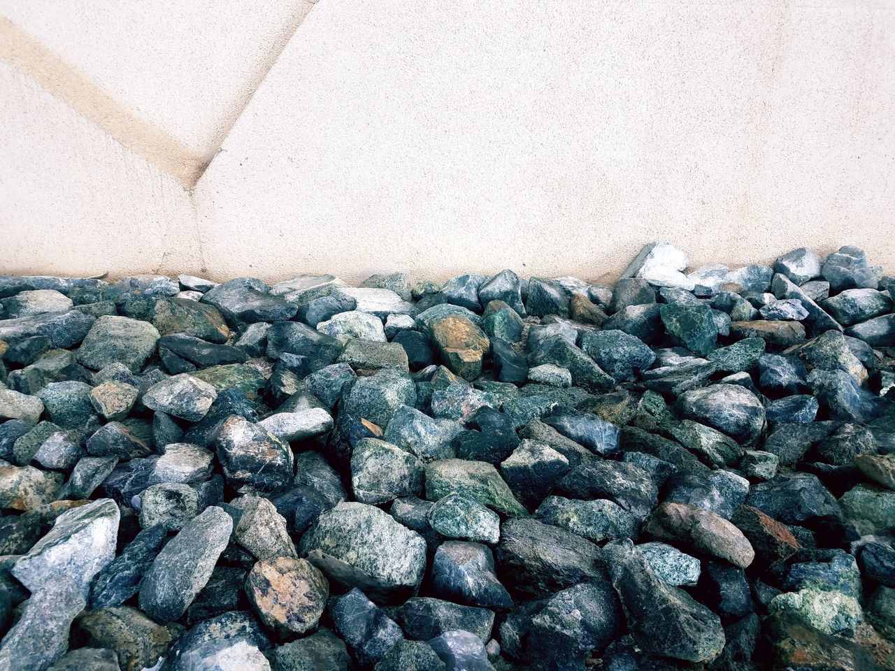 CLOSE-UP OF STONES ON ROCKS AGAINST WALL