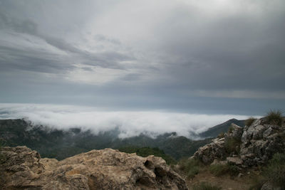 Scenic view of mountains against cloudy sky