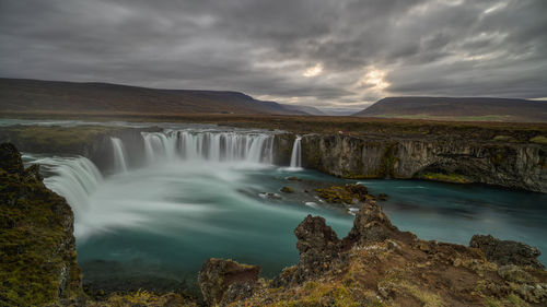 Scenic view of waterfall against sky