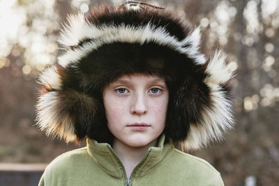 Portrait of boy in ushanka standing outdoors during winter