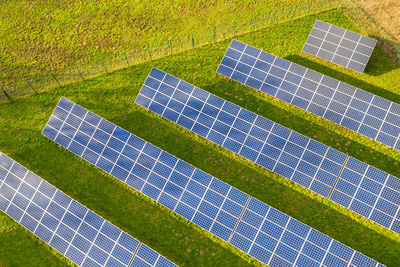 High angle view of solar panels on grassy field