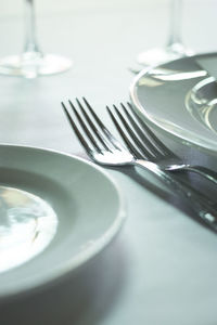 Close-up of forks by plates on table