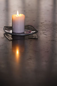 Lit candle on table