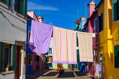 Clothes drying on alley amidst buildings in city