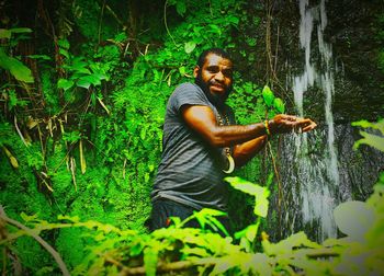 Man holding plant in forest