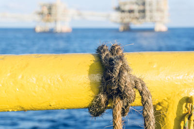 Manila rope tied on a handrail onboard a construction work barge while in operation at oil field 