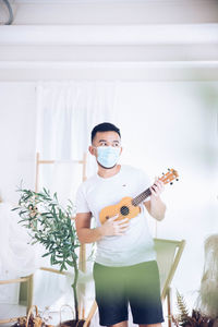 Portrait of young woman playing guitar