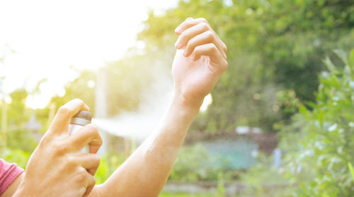 Cropped hand of woman against plants