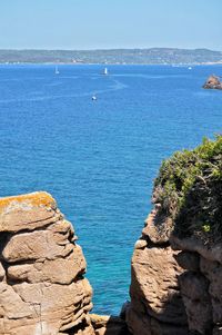 Scenic view of cliffs and sea against sky