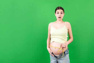 Portrait of a beautiful young woman over green background