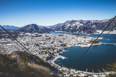 Overhead cable cars against lake kawaguchi and townscape during winter