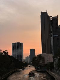 Modern cityscape against sky during sunset