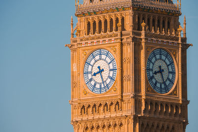 Low angle view of clock tower against clear blue sky