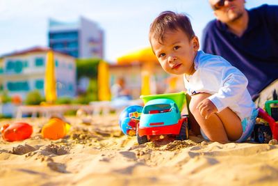 Close-up of boy playing on sand at playground