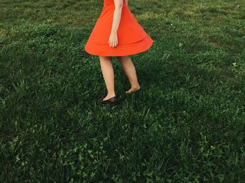 Low section of woman standing on grassy field