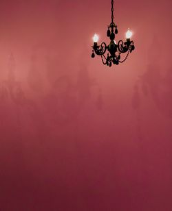 Low angle view of illuminated chandelier against sky during sunset