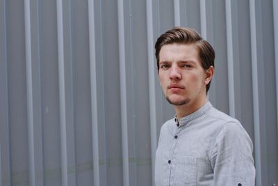 Front view of handsome man standing against wall