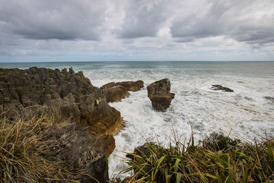 Rocks on sea shore against sky