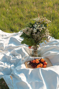 Summer picnic blanket with strawberries and wildflowers. vertical life style photo.