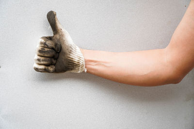 Close-up of human hand against wall