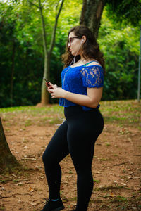 Side view of teenage girl standing on field at park