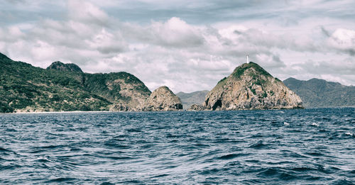 Scenic view of sea and mountains against sky