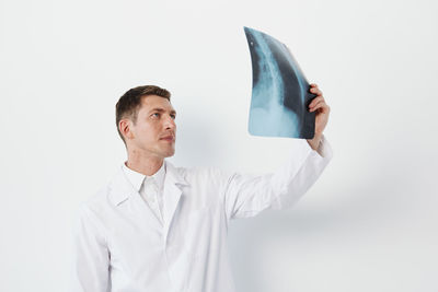 Portrait of doctor standing against white background